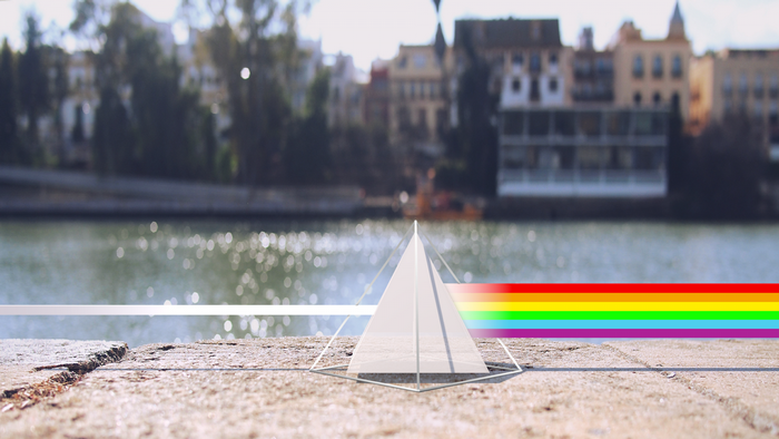 Prism refracting light into a rainbow over a river