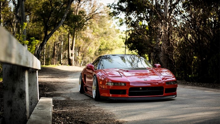 Red Acura NSX sports car on a dirt road