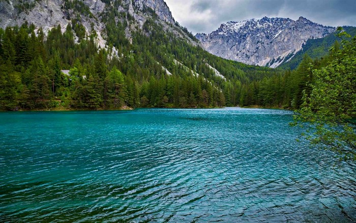 Turquoise lake surrounded by green forest and mountains