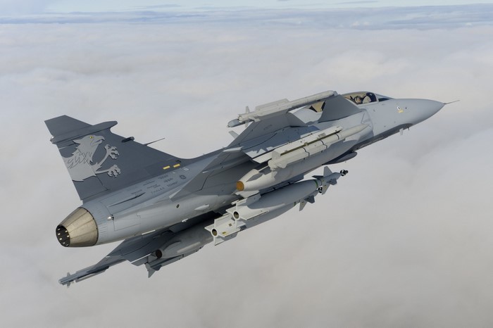 JAS 39 Gripen fighter jet flying above clouds