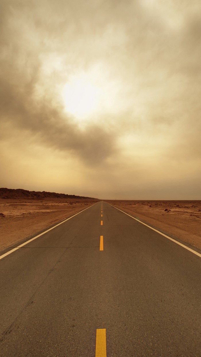 Desert highway under cloudy sky