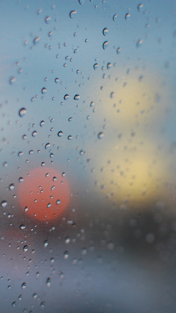 Raindrops on glass with blurred lights