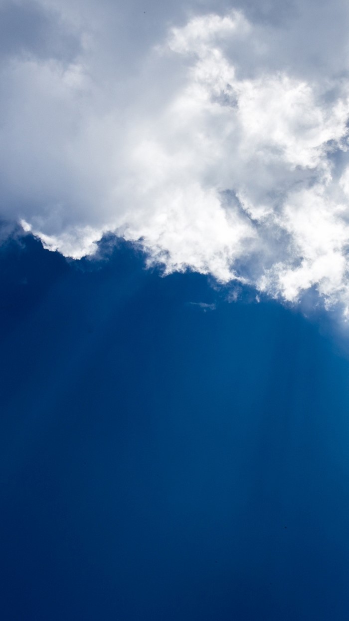 Sunlight filtering through clouds in a blue sky