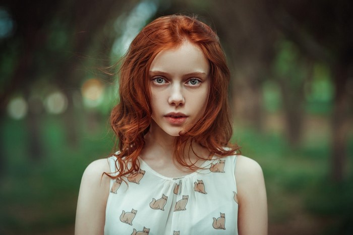 Portrait of a young woman with red hair and blue eyes
