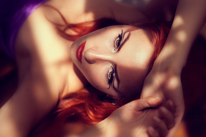 Woman with red hair and dramatic makeup