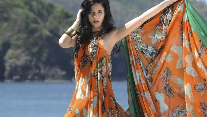 Model in a butterfly print dress by the water