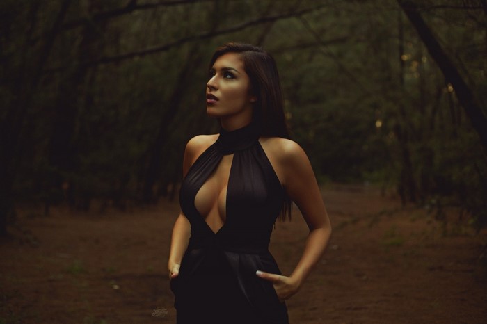 Woman in black dress in a dark forest