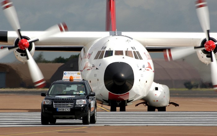 Land Rover follows Transall C-160 military aircraft on tarmac