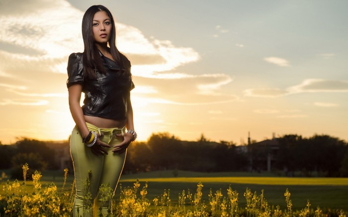 Woman in leather jacket and yellow pants at sunset