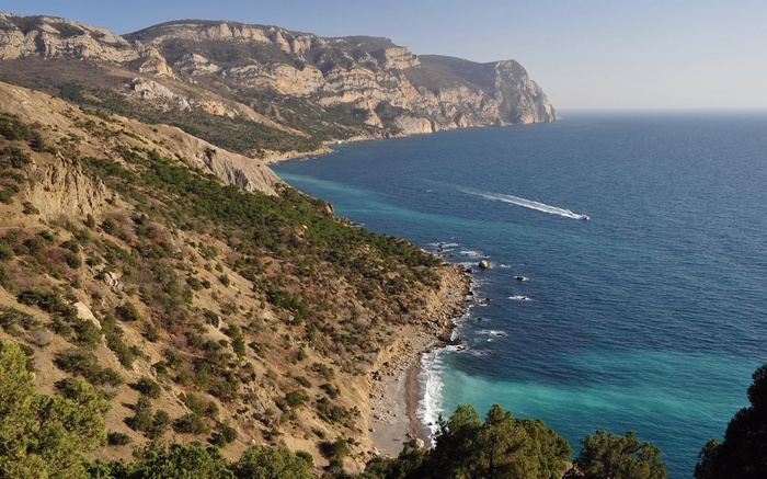 Coastal cliffs and sea with a boat