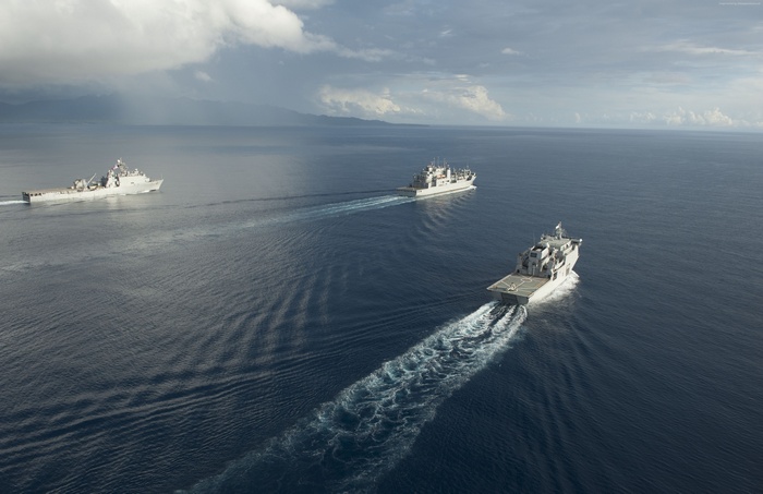 Three US Navy ships sailing in the ocean