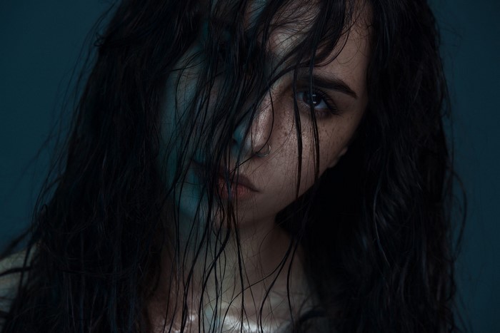 Woman with wet black hair and freckles