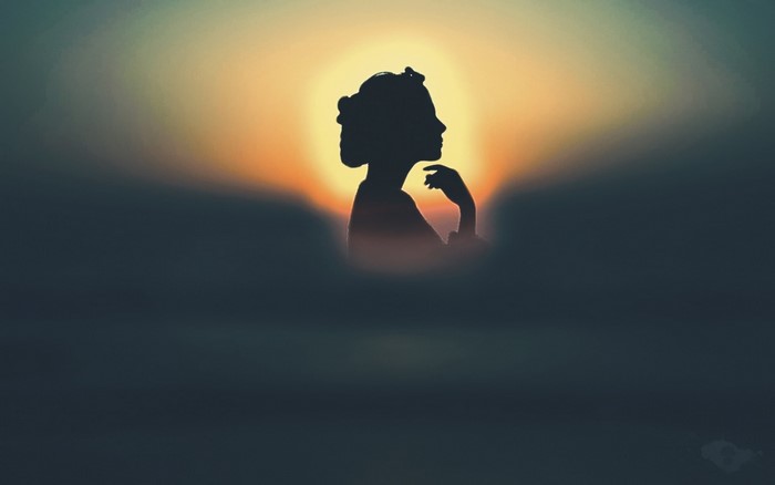 Silhouette of a woman against a sunset