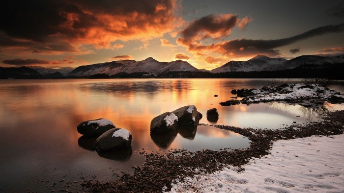 Sunset over a snowy lake and mountains
