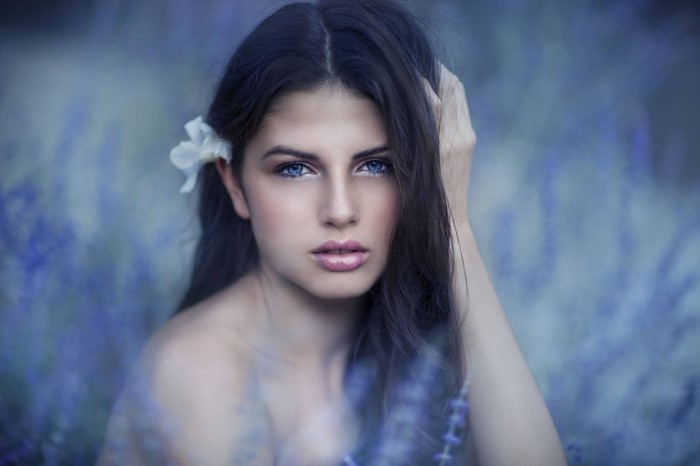 Woman with blue eyes and white flower in her hair