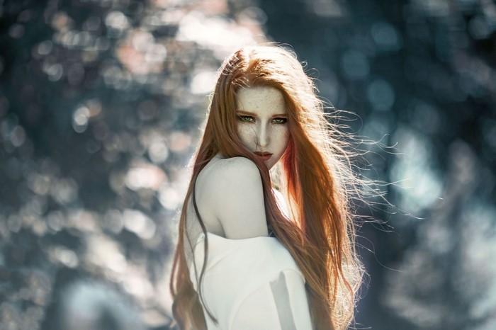 Redhead woman with long hair in a white top