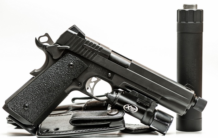 Black 1911 pistol with silencer and flashlight