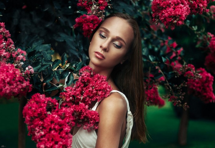 Woman in white dress surrounded by pink flowers
