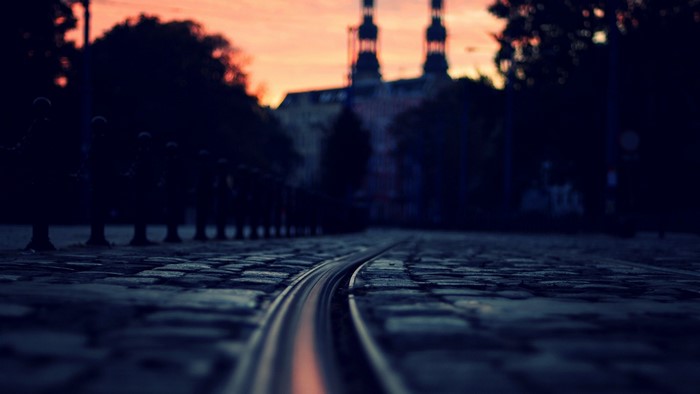 Tram tracks on cobblestone street at sunset
