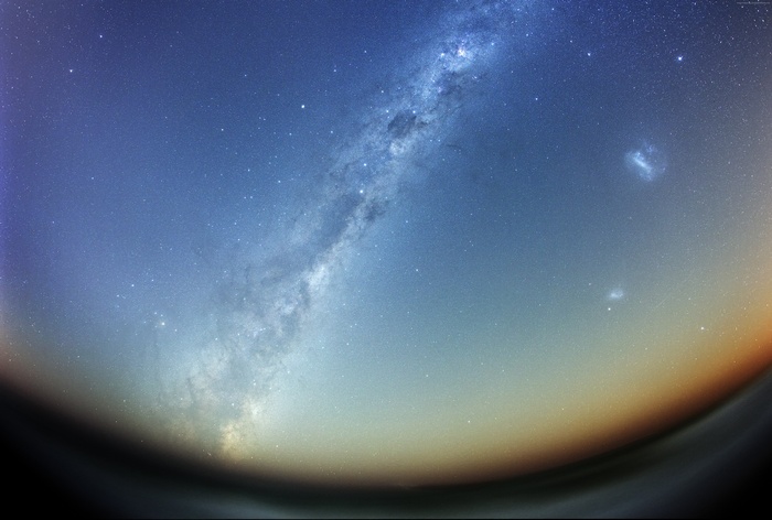 Milky Way galaxy over a dark horizon