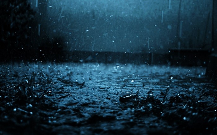 Rain falling on dark ground