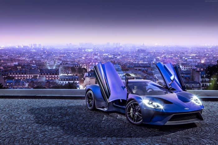 Blue Ford GT supercar with doors open overlooking city