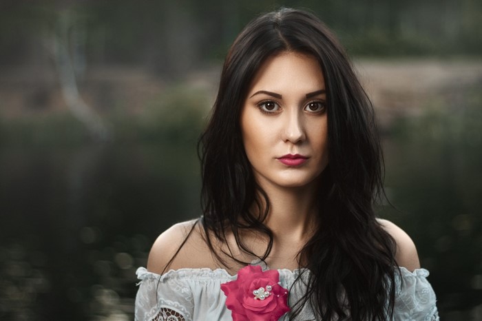 Woman with dark hair and a pink rose accessory