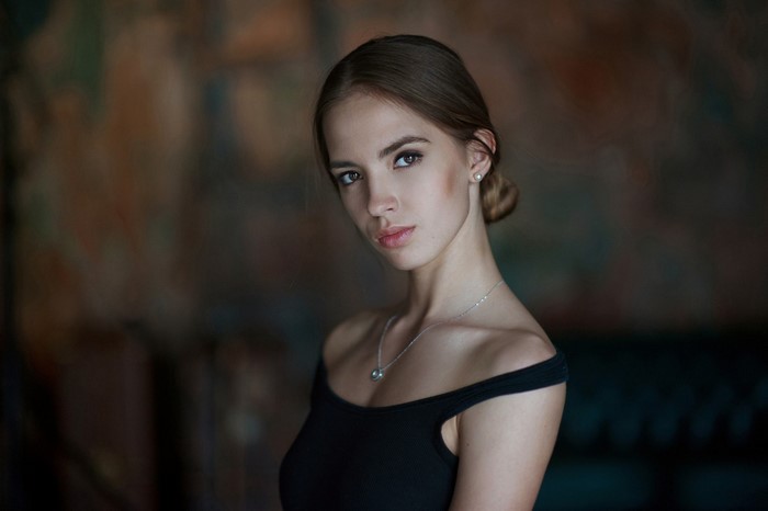 Portrait of a young woman with brown hair tied back