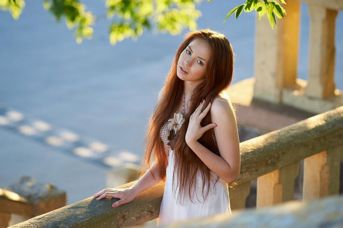 Redhead woman with long hair in a white dress