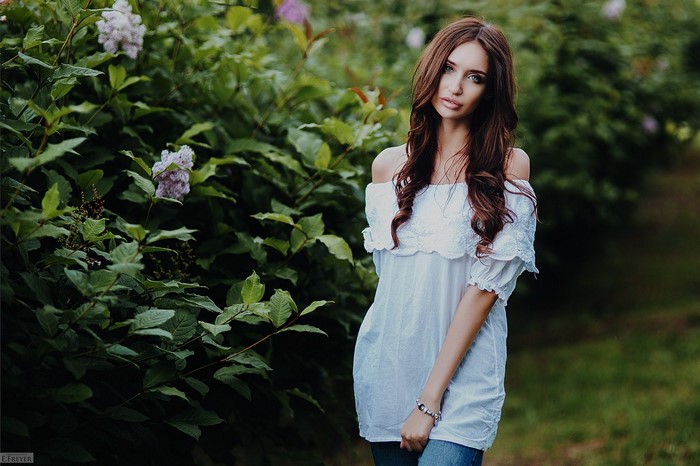 Woman in white off-the-shoulder top and jeans outdoors