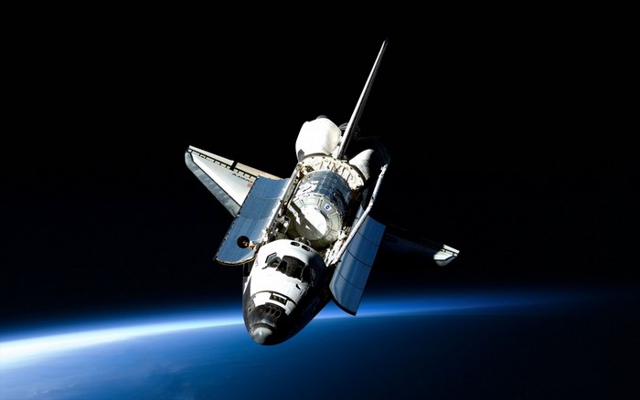 Space Shuttle Atlantis with payload in orbit above Earth