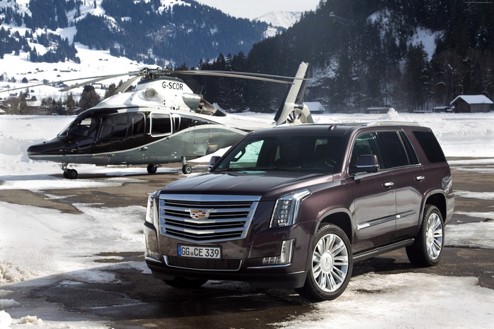 Cadillac Escalade Platinum and helicopter in snowy mountains