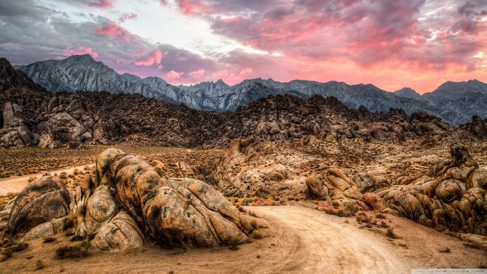 Rocky desert landscape with mountains at sunset