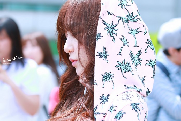 Woman with brown hair wearing a pink hoodie with palm trees