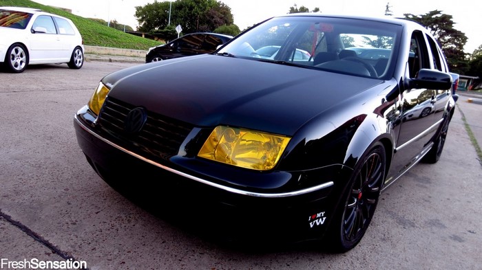 Black Volkswagen Bora with yellow headlights
