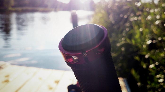 Close-up of a bicycle handlebar grip by a lake at sunset