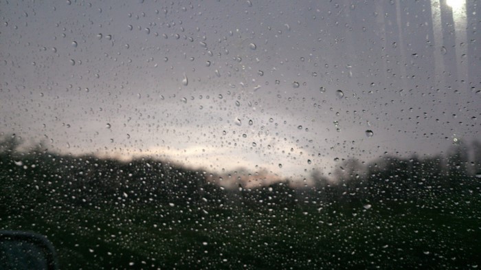 Raindrops on a window with a blurry landscape