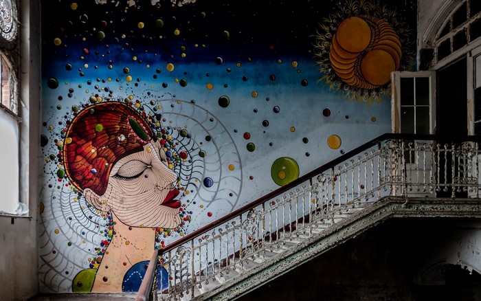 Graffiti mural of a woman's face with bubbles and a sun