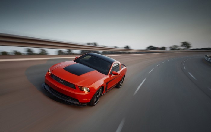 Red Ford Mustang Boss 302 on a curving road