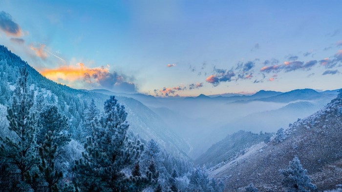 Winter mountain valley at sunrise with frosted trees