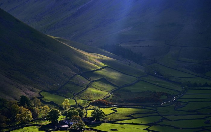 Sunlight on a green valley with stone walls