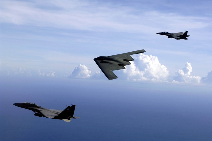 B-2 Spirit bomber with two F-15E Strike Eagles