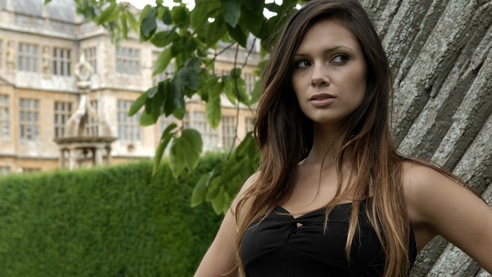 Woman with long brown hair posing outdoors