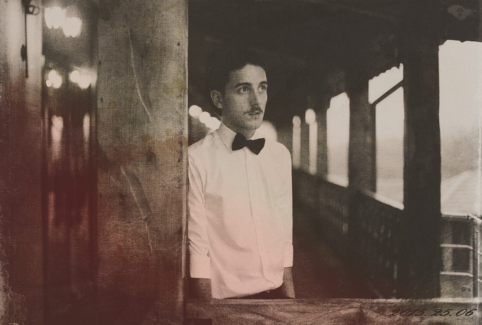 Man in white shirt and bow tie on a vintage train