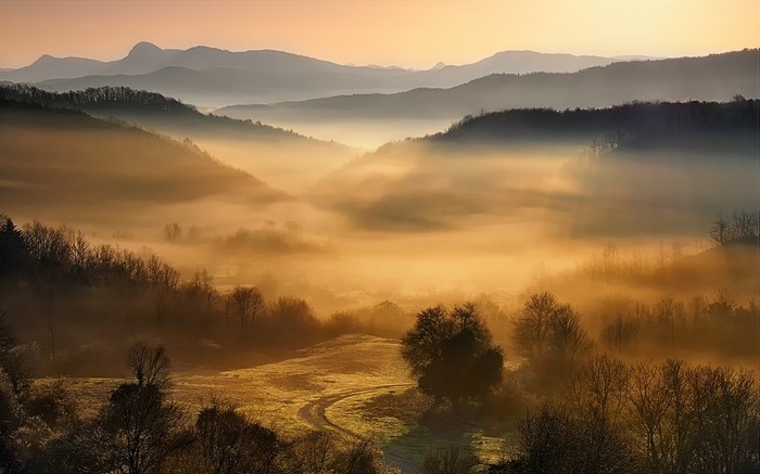 Misty mountain valley at sunrise or sunset