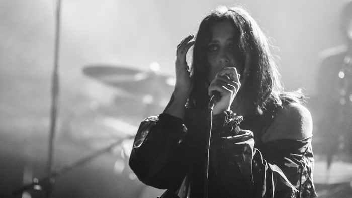 Chelsea Wolfe singing into a microphone on stage