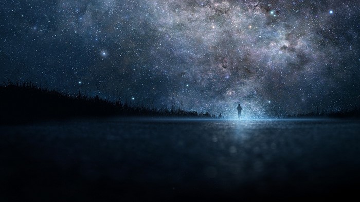 Person standing under a starry night sky