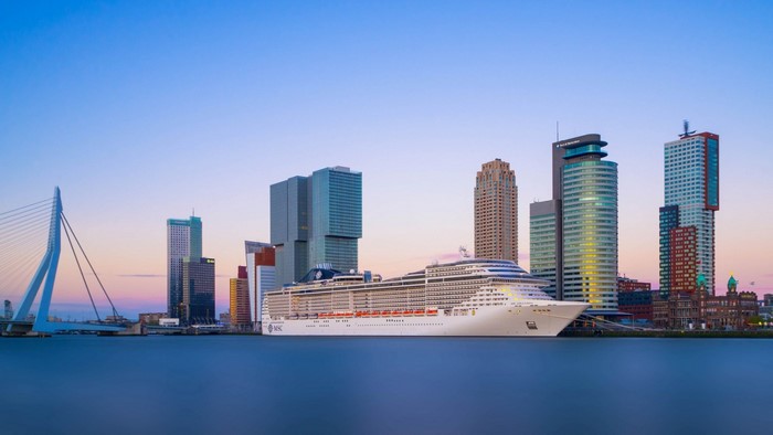 Cruise ship docked in Rotterdam cityscape with Erasmus Bridge