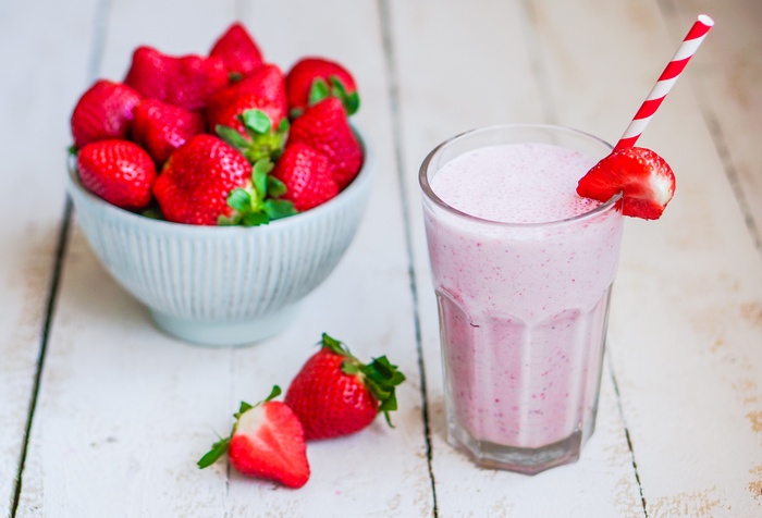 Strawberry smoothie with fresh strawberries in a bowl