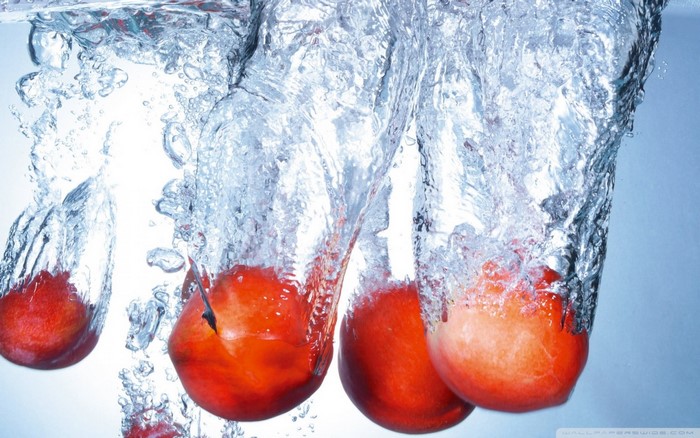 Peaches splashing into water